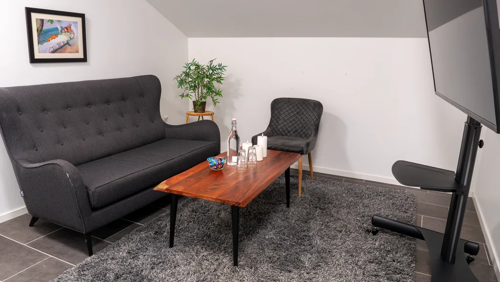 Rum under trappa på WeSpace med soffa, soffbord och skärm